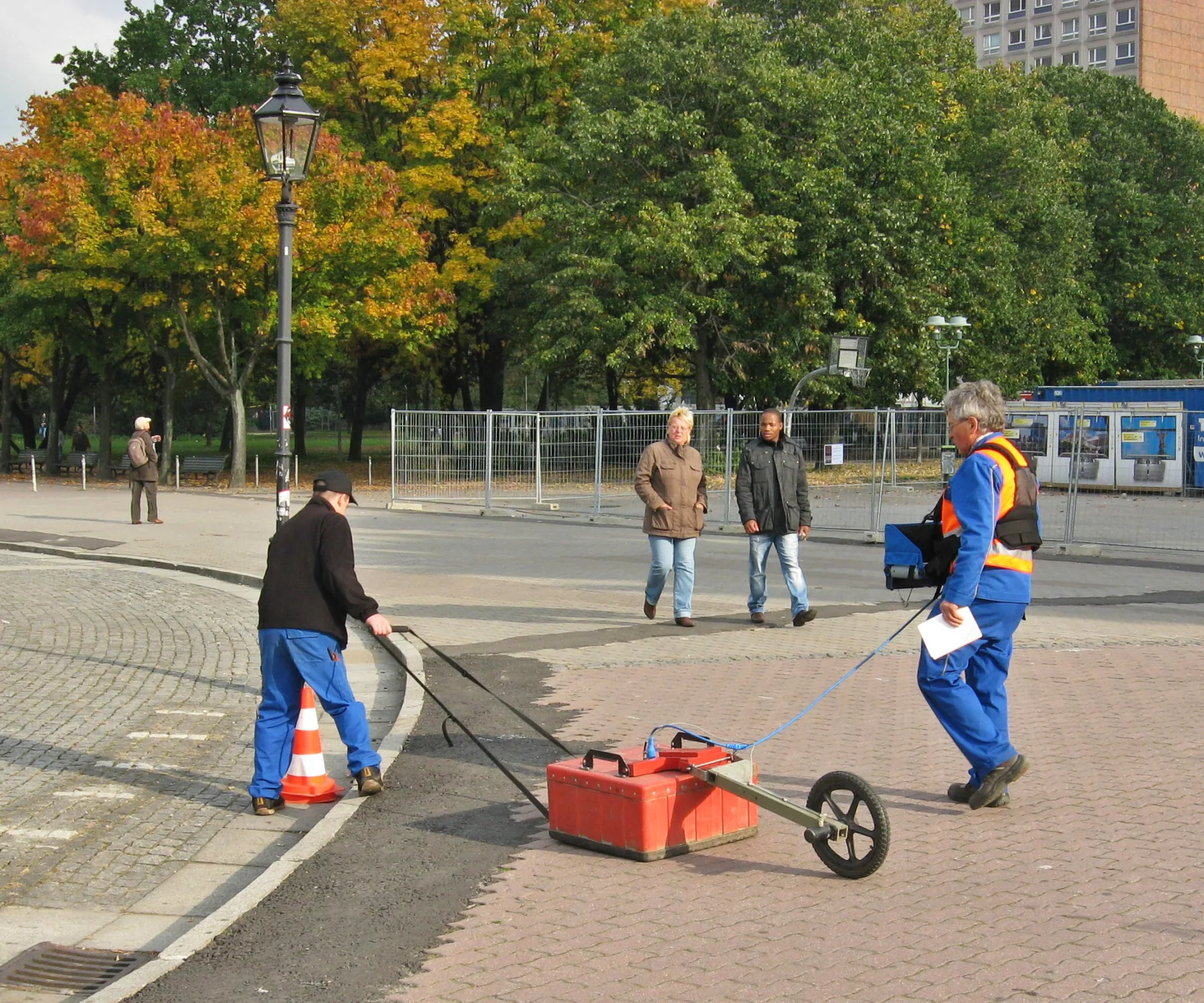 Researchers running a ground-penetrating radar survey over paving stones at an archaeological site in Berlin